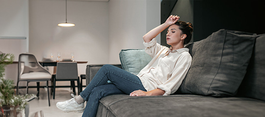 Woman sitting in humid living room 